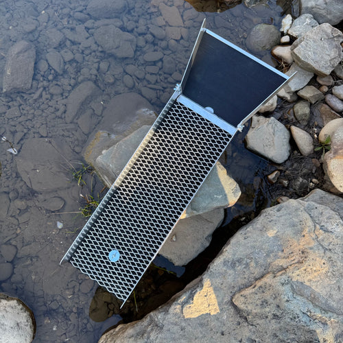 Aluminium sluice displaying aluminium expanded mesh and black riffle matting in a creek setting.